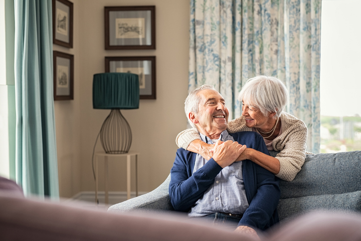 Senior Couple Hugging And Having Fun At Home